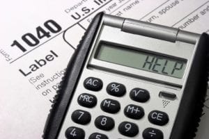 A calculator reading "help" on the IRS Form 1040