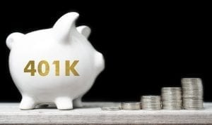 401(k) piggy bank with stacks of coins