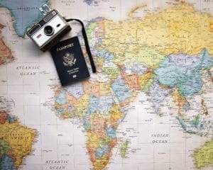 A US passport, and a camera resting on a map of the world