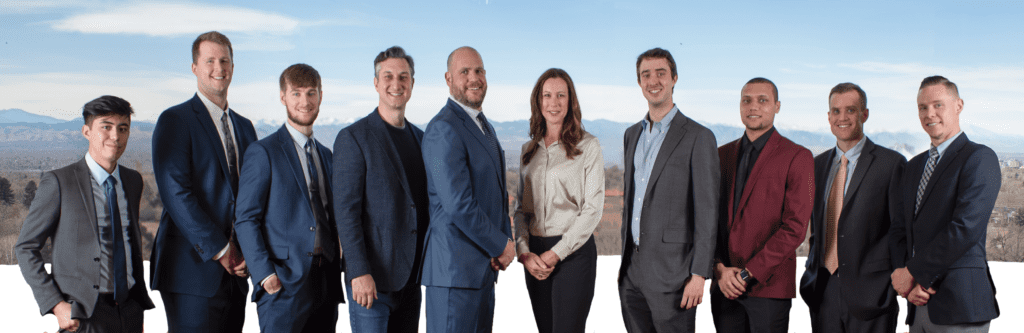 A team of ten tax professionals posing in front of denver colorado's front range