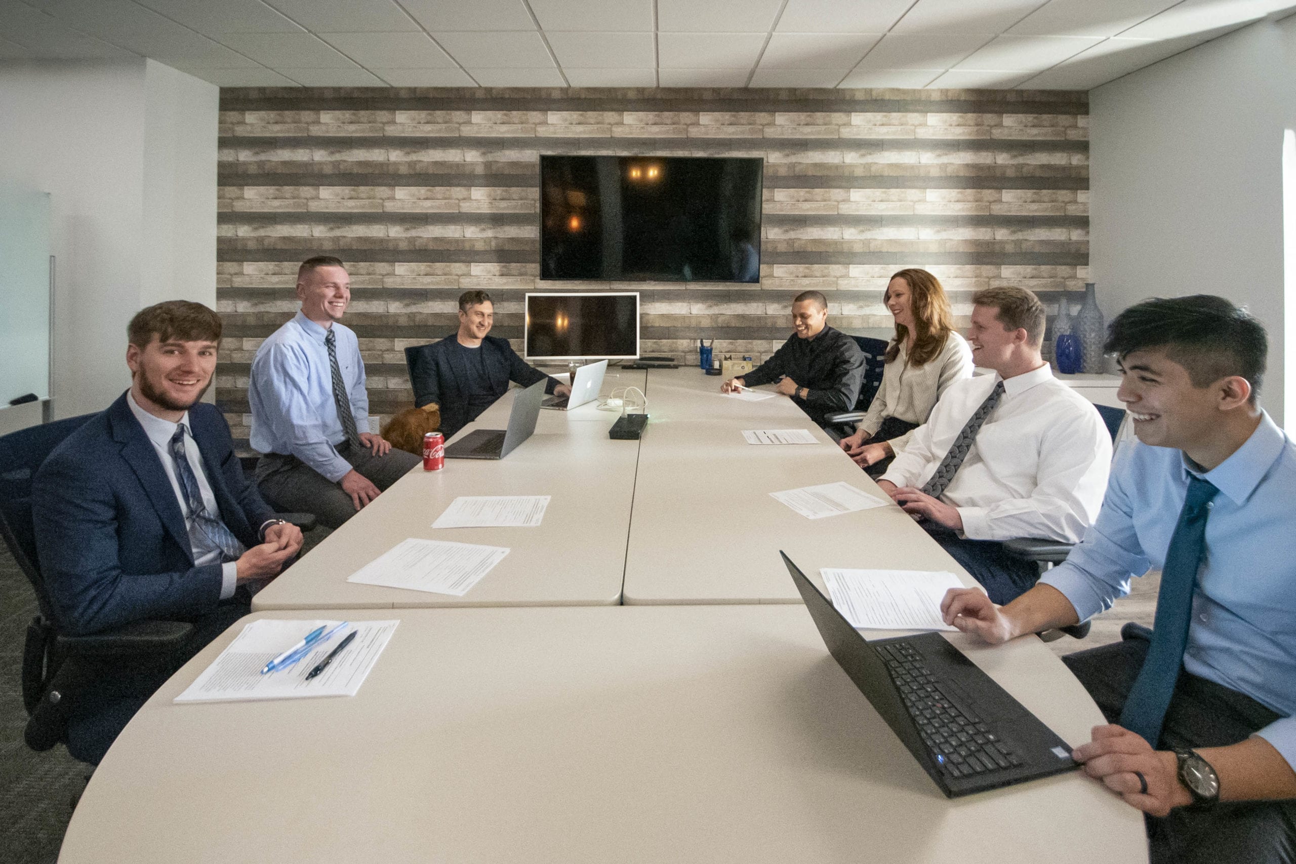 A team of seven professionals meeting at a conference table