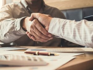 Two businessmen shake hands on an agreement for an Installment Sale.