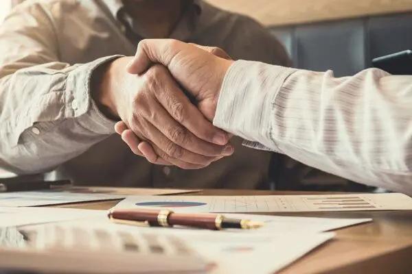 Two businessmen shake hands on an agreement for an Installment Sale.